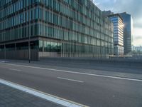 the road is empty on this busy street with the tall building in the background for pedestrians