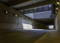 a roadway in a tunnel with yellow lights and no street lights on either side of the road