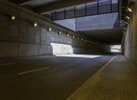 a roadway in a tunnel with yellow lights and no street lights on either side of the road