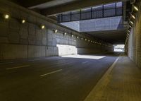 a roadway in a tunnel with yellow lights and no street lights on either side of the road