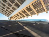 the roof on a long bridge is made of windows and a street light that lights up over the walkway