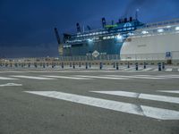 a large blue ship parked on the dock with a lot of markings in front of it