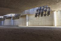 a building with a concrete wall and graffiti on it's side, next to dirt