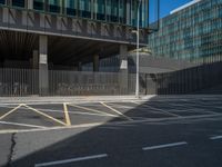 there is a fence and parking area near the side of a building on a street corner