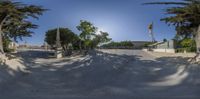 a panorama lens shot of a street in the afternoon light in front of a building