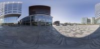 the circular picture is shown with two buildings in the background and another building behind it