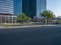 an empty street in front of a building and trees on the other side of the road