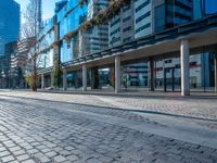 an empty street with some buildings and cars in the distance with blue sky overhead in downtown vancouver, canada