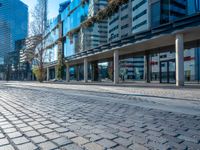 an empty street with some buildings and cars in the distance with blue sky overhead in downtown vancouver, canada