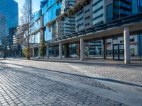 an empty street with some buildings and cars in the distance with blue sky overhead in downtown vancouver, canada