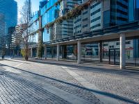 an empty street with some buildings and cars in the distance with blue sky overhead in downtown vancouver, canada