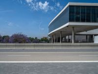 a building with many windows next to the road with no people or vehicles outside of it