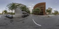 360 - 360 view of street traffic in urban city area with buildings and trees, cars parked on both sides