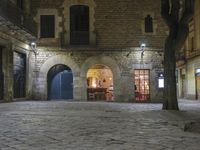 an empty cobble stone area with furniture and tables in the background at night time