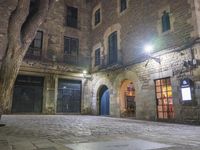 an old building at night with two doors and some windows on it's sides