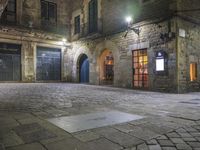 an old building at night with two doors and some windows on it's sides