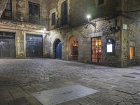 an old building at night with two doors and some windows on it's sides