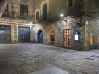 an old building at night with two doors and some windows on it's sides