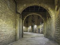 an alley way with stone floors and stone arches and an archway to the side and floor