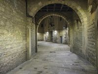 an alley way with stone floors and stone arches and an archway to the side and floor