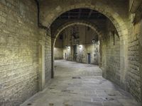 an alley way with stone floors and stone arches and an archway to the side and floor