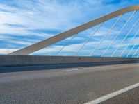 a highway with a bridge over it with a sky background and some clouds in the background