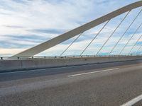 a highway with a bridge over it with a sky background and some clouds in the background