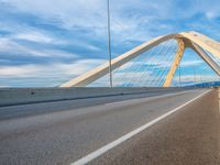 an overhead shot of a roadway with a bridge in the background and blue skies above