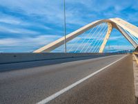 an overhead shot of a roadway with a bridge in the background and blue skies above