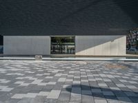 a white building next to a pool in a courtyard area with a walkway leading into it