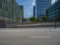 a long empty parking lot with a skateboard on the street and a few buildings behind it