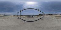 an image of a fish eye lens view of the ocean from a bridge with bars and railings