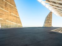 a young man in black skate board on a ramp next to building with two triangular shaped towers