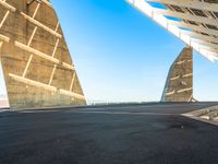 a young man in black skate board on a ramp next to building with two triangular shaped towers