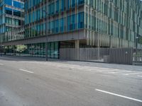 a man is crossing a street with a white boarder and a blue car parked by the building