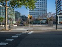 an empty street in front of a building and trees on the other side of the road