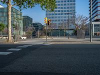 an empty street in front of a building and trees on the other side of the road