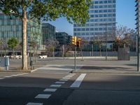 an empty street in front of a building and trees on the other side of the road