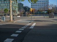 an empty street in front of a building and trees on the other side of the road