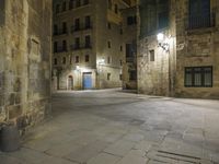 there is an empty courtyard in a big city at night with lights on the buildings