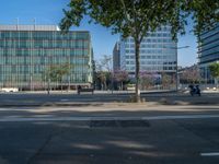 an empty street in front of a building and trees on the other side of the road