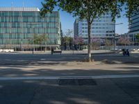 an empty street in front of a building and trees on the other side of the road