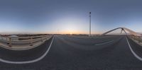 the sun is shining over a bridge and water in the distance, as seen through a 360 - view lens