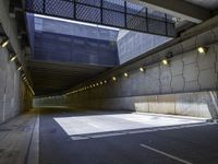 a dark parking space with concrete floors and overhead lighting on top of the garage wall