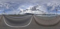 a fish eye photo of an empty street and highway, taken from the side of a bridge