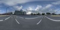 a road in a roundabout with an empty street between it and a group of tall buildings