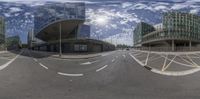 three large buildings stand in the foreground of a busy street and is reflected by a very fish eye lens