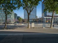 an empty street in front of a building and trees on the other side of the road