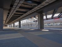 a picture of the underside of a train station on tracks, with lots of empty and concrete