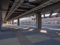 a picture of the underside of a train station on tracks, with lots of empty and concrete